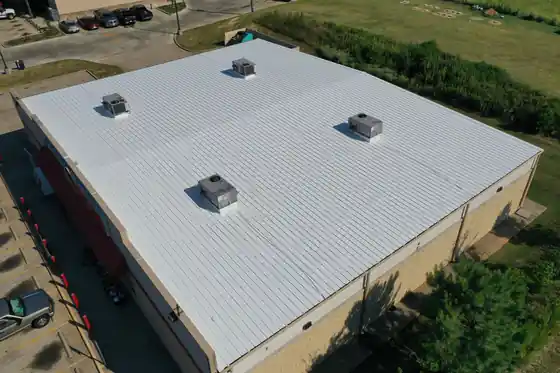 Oblique drone view of a commercial building with a white metal roof