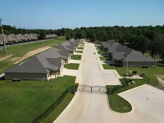 Aerial view of a gated townhome street with matching new roofs