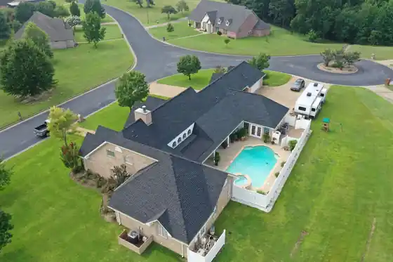 Oblique drone view of an estate with a pool and an RV on a cul-de-sac