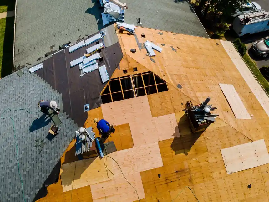 Drone view of a BXC crew mid tear-off, half old shingles and half bare decking