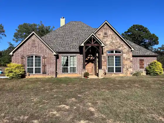 Stone home with a gabled entry under a blue sky