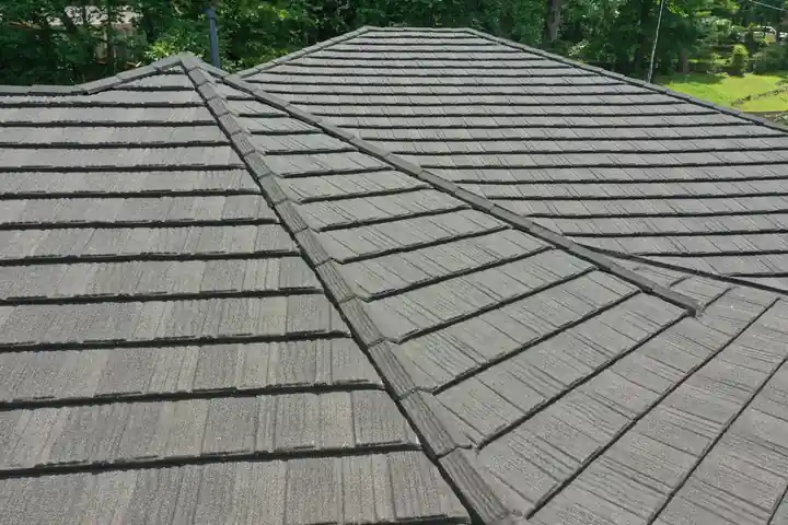 Close detail of stone-coated shake courses meeting at a hip