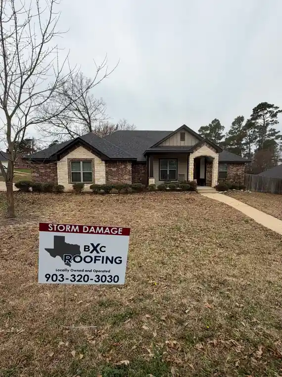 BXC Roofing storm damage yard sign in front of a brick home
